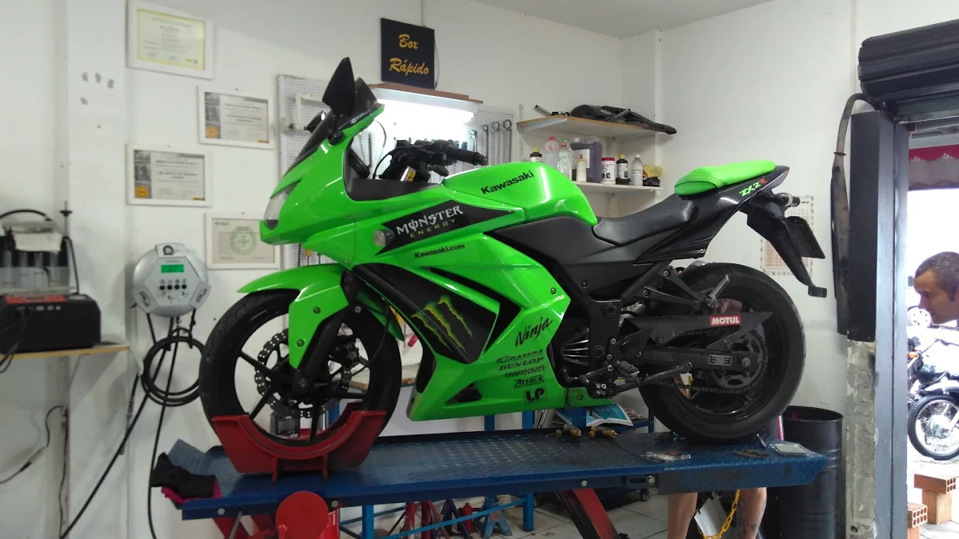 Moto esportiva verde em bancada de oficina